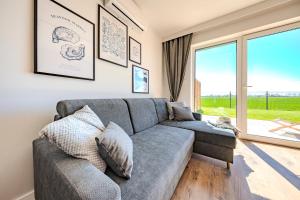 a living room with a couch and a large window at Stegnova domki w Stegnie in Stegna +44 photos