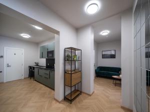 a kitchen and a living room with a green couch at M6 Rooms Riga in Riga