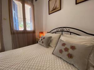 a bedroom with a bed with pillows and a window at Ravanos Apartment in Loutraki
