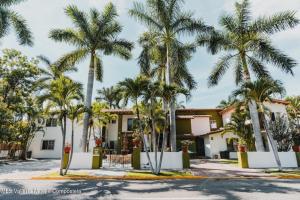 a group of palm trees in front of a building at Casa Virgilio B&B in Nuevo Vallarta