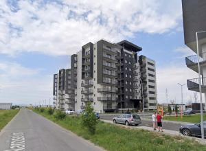 two people standing on the side of a road with a building at Modern Spacious Mountain View Apt in Braşov