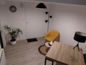 a living room with a table and a chair at Comme à la maison in Ernée