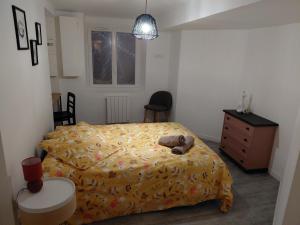 a bedroom with a bed with a teddy bear on it at Comme à la maison in Ernée