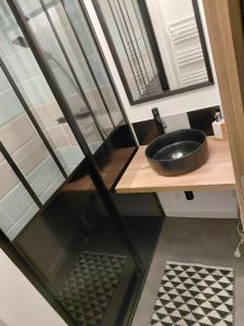 a bathroom with a black sink on a counter at Comme à la maison in Ernée