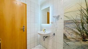 a bathroom with a sink and a mirror at CBlue "Apartmenthaus Chrischanshof" in Warnemünde +55 photos