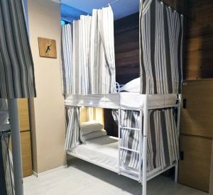 a bunk bed with white curtains in a bedroom at Zippy Hostel in Milan +10 photos