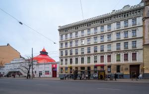 a building with a red roof on a city street at M6 Rooms Riga in Riga