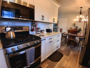 a kitchen with a stove and a kitchen with a table at By Summersville Lake 3BR Jetted Tub Sauna in Craigsville