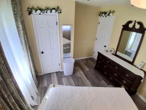 a bedroom with a mirror and a bed and a sink at By Summersville Lake 3BR Jetted Tub Sauna in Craigsville +43 photos