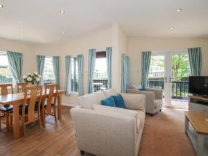 a living room with a table and a dining room at Daffodil in Leominster