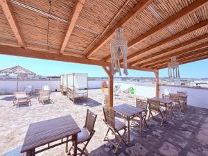 a group of tables and chairs on a patio with the beach at B&B La Maiolica - di Galatea casa vacanze in Corsano