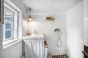 a white bathroom with a sink and a shower at AE326-Marstal-Pers-Bro-6 in Marstal
