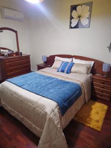 a bedroom with a bed and a dresser and a mirror at Madeira Home Holidays in Caniço