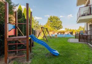 a playground with a slide in a yard at Mierzeja Bliss Point - Basen, Parking, Grill in Sztutowo