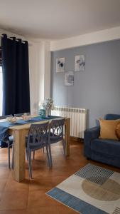 a living room with a table and a blue couch at Casa Vacanze Palidoro Il Plumbaco in Palidoro