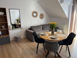 a living room with a table and a couch at Mierzeja Bliss Point - Basen, Parking, Grill in Sztutowo