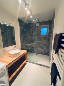 a bathroom with a sink and a shower at Seaward Cottage met Jacuzzi in De Haan