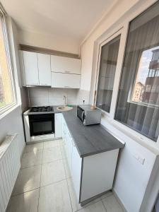a kitchen with white cabinets and a counter with a microwave at RC RelaxApart 602 in Dudu