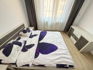 a bedroom with a bed with purple and white sheets at RC RelaxApart 602 in Dudu