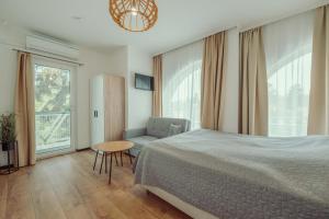 a bedroom with a bed and a chair and a table at Caesar Apartments & Rooms in Siófok