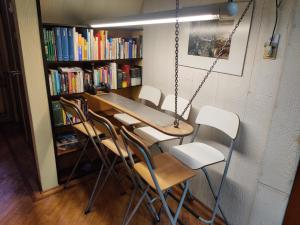 a table and chairs in a room with bookshelves at Frank's Backpackers in Helmond