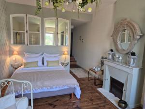 a bedroom with a white bed and a fireplace at La Bâtisse de Bromont in Bromont-Lamothe