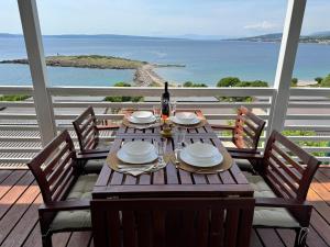 a table with plates and a bottle of wine on a balcony at Adriastay 360 in Klenovica