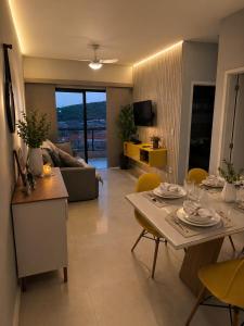 a kitchen and living room with a table and chairs at Lisboa Hospedaria 300 m da praia do forte in Cabo Frio