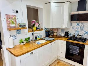 a kitchen with white cabinets and a wooden counter top at 31 Sailsbury road in Marlborough