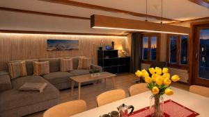 a living room with a couch and a table with yellow flowers at CLOUD No3 Schweizer Chalet-Wohnung mit zentraler Klimaanlage in Matten