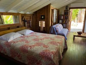 a bedroom with a bed and a chair and window at La Voile Grise - Villa de charme - Sea View in Le Gosier +28 photos
