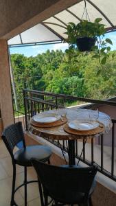 a table and chairs on a balcony with a view at Edícula Recanto das Palmeiras in Uberaba