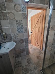 a bathroom with a shower and a sink and a door at Kellaki Village House in Kellaki +17 photos