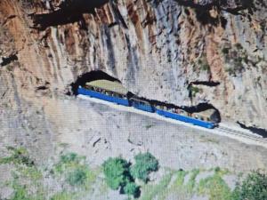 a train is going through a tunnel in a mountain at Ζachlorou Inn in Kalavrita