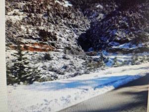 a painting of a snow covered road with a blue at Ζachlorou Inn in Kalavrita