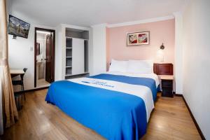 a hotel room with a blue and white bed at HOTEL AMERICANA PASTO in Pasto