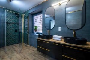 a bathroom with two sinks and a glass shower at Slotvin Apartments in Słotwiny +50 photos
