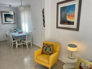 a living room with a yellow chair and a table at The Town House - Mojacar in Mojácar