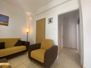 a living room with a couch and a chair at Ravanos Apartment in Loutraki +19 photos