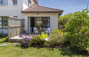 a house with a garden with a wooden deck at Garden View Studio in Plettenberg Bay