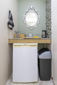 a bathroom with a vanity with a mirror and a trash can at Garden View Studio in Plettenberg Bay