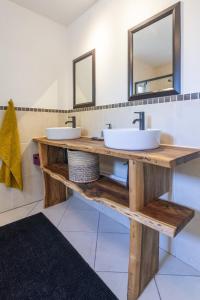 a bathroom with two sinks and two mirrors at Garden View Studio in Plettenberg Bay +4 photos