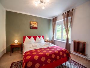 a bedroom with a bed with a red blanket and a window at Faaker See Inn by Aurora in Faak am See