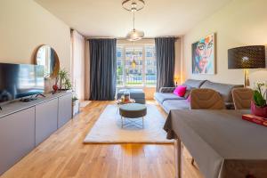 a living room with a couch and a tv at Les Faberges in Carpe Vita in Varna City