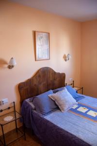 a bedroom with a bed with a wooden head board at Apartamentos Casa Ferrás in Valderrobres