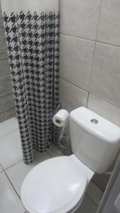 a bathroom with a white toilet and a shower at Edícula Recanto das Palmeiras in Uberaba +14 photos