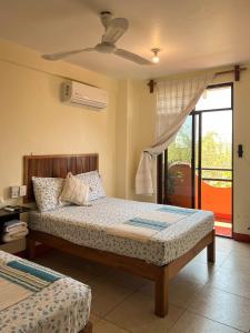 a bedroom with two beds and a ceiling fan at Bacanda Hotel in Puerto Escondido
