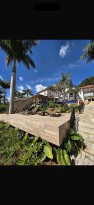 a wooden walkway with benches and a palm tree at Chalés Pôr do Sol in Tiradentes