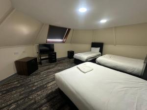 a hotel room with two beds and a television at Park hotel in Bradford