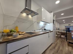 a kitchen with white cabinets and a counter with a bowl of fruit at Loft Centrico Tantín RH 17 in Santander